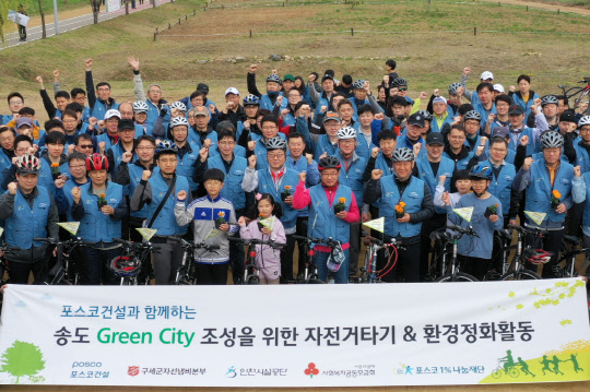 포스코건설 봉사단은 지난 20일 인천 송도 달빛공원, 해돋이공원에서 자전거를 타면서 꽃밭을 가꿨다. 사진은 포스코건설 봉사단이 기념촬영을 하고 있는 모습. <포스코건설 제공>